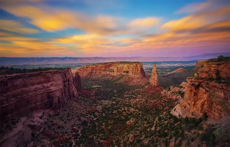 Red rock canyon landscape at sunset with towering cliffs and colorful desert skies