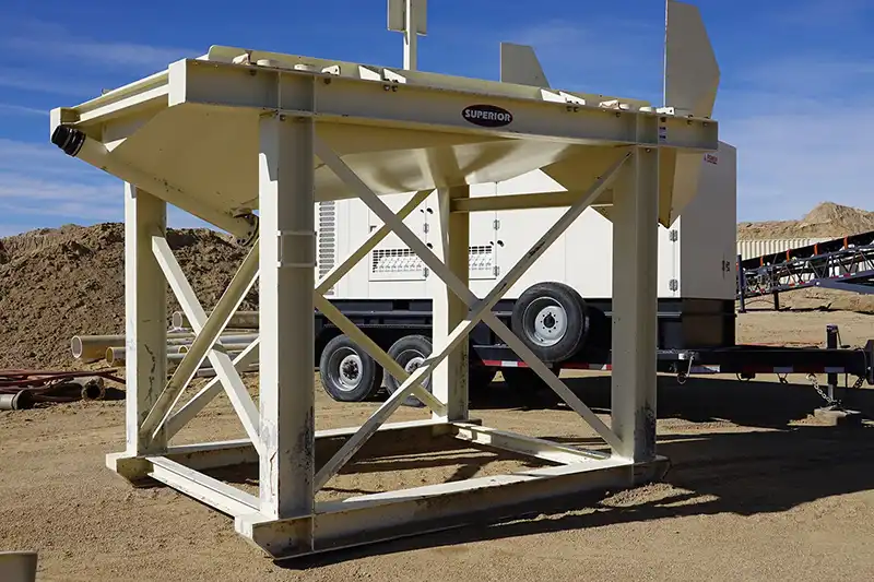 Superior feed hopper for aggregate material handling at a portable processing plant